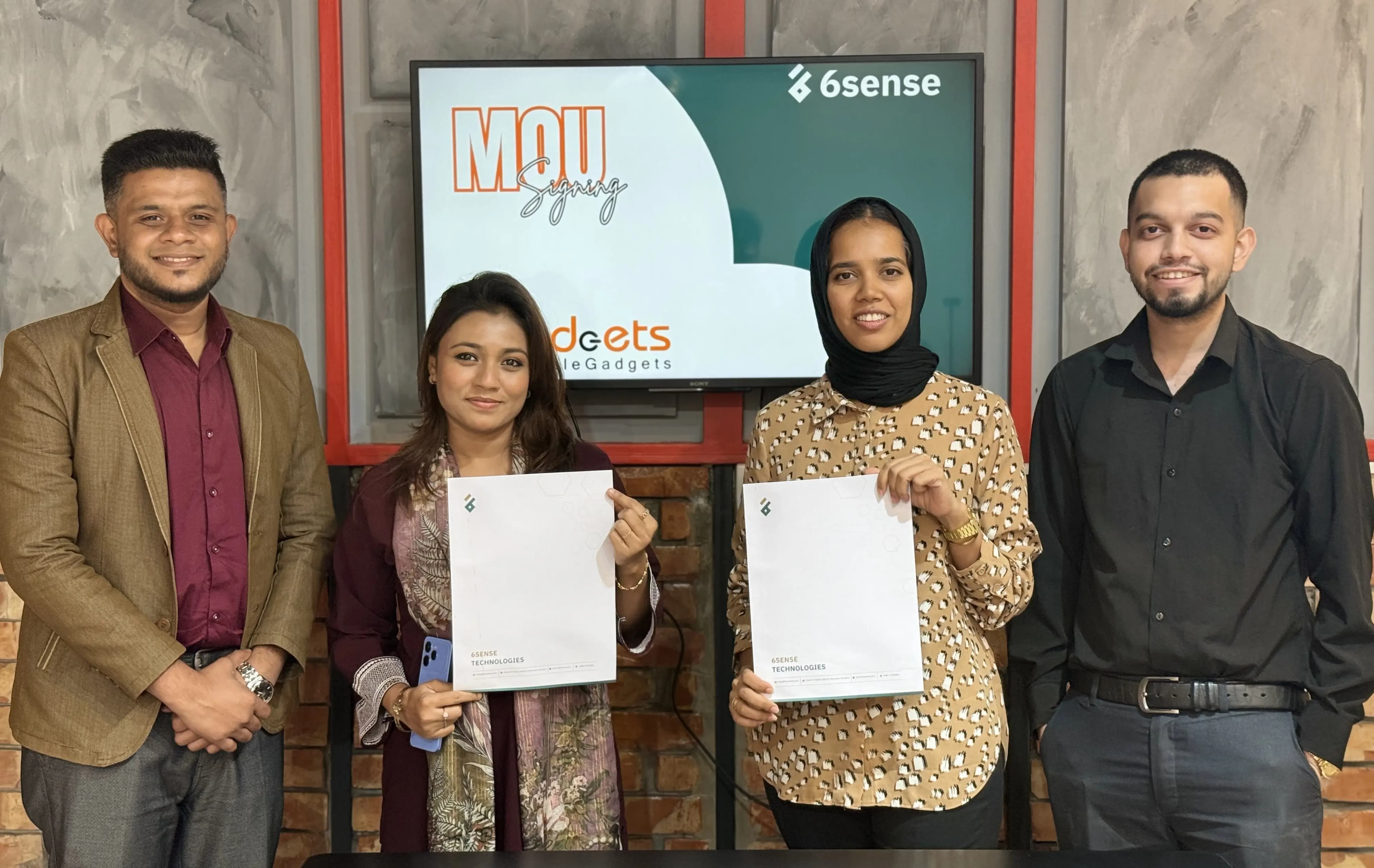 6sense team and Apple Gadgets representatives at an MOU signing ceremony holding agreement documents
