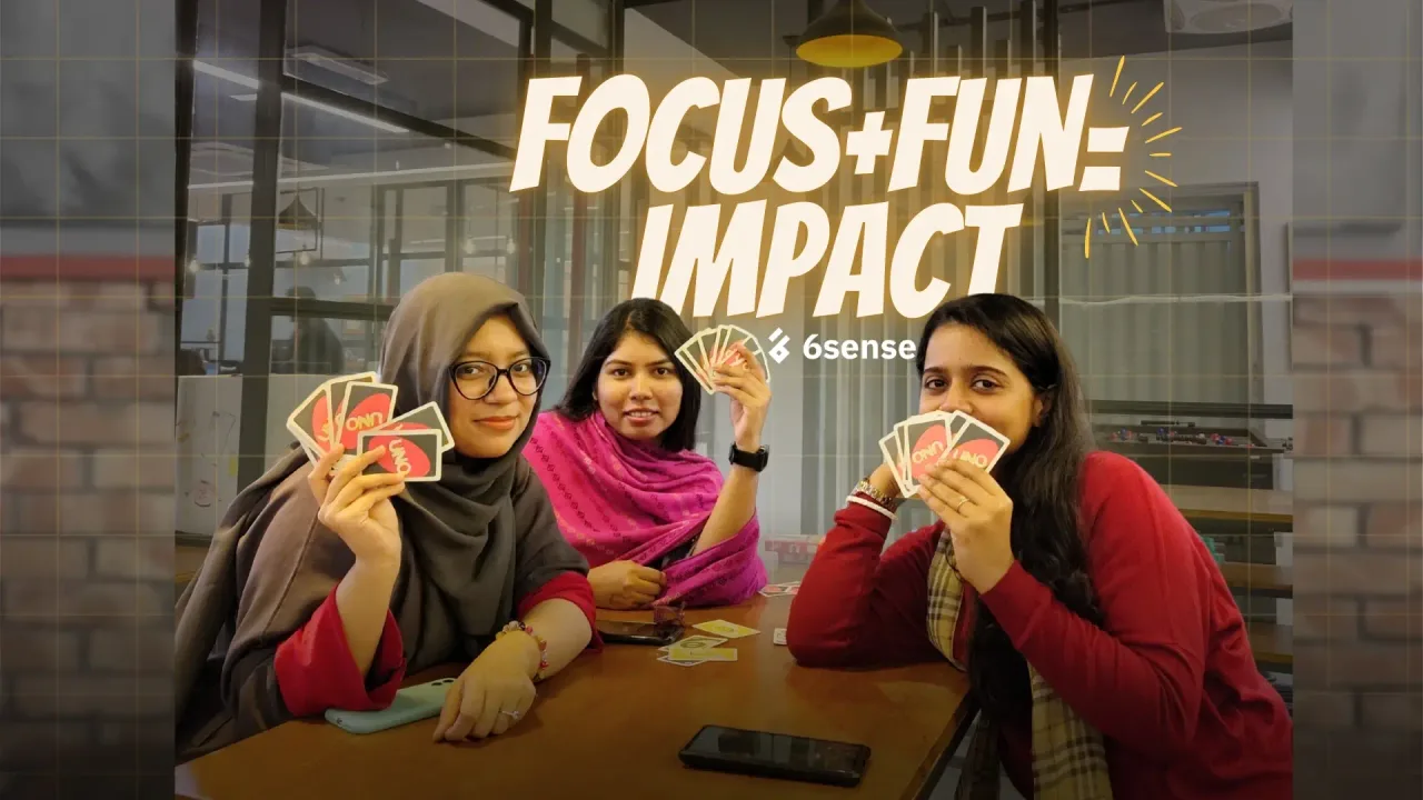A 6sense HQ teammate holding a “Focus + Fun = Impact” sign